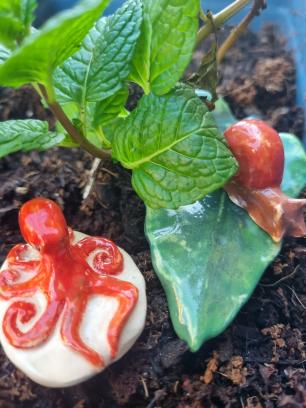 2 small ceramic animals next to a plant
