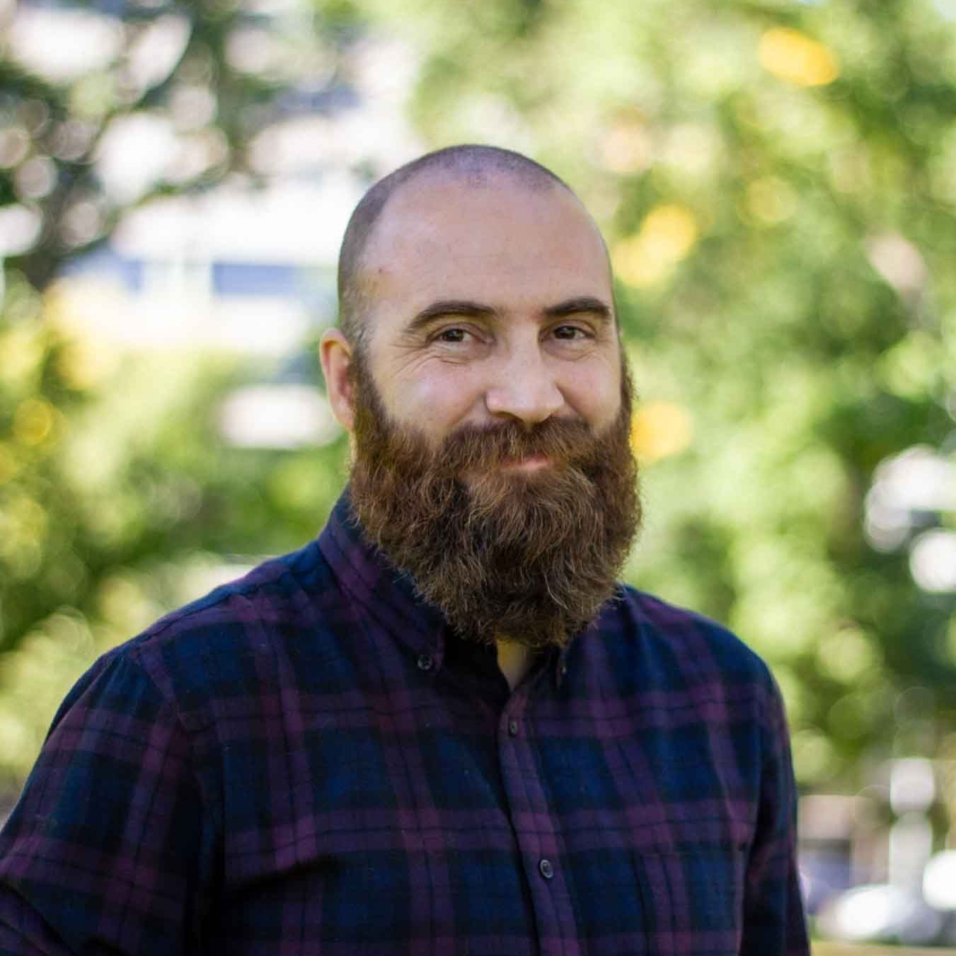 Simon, a man with a beard, smiling at the camera.