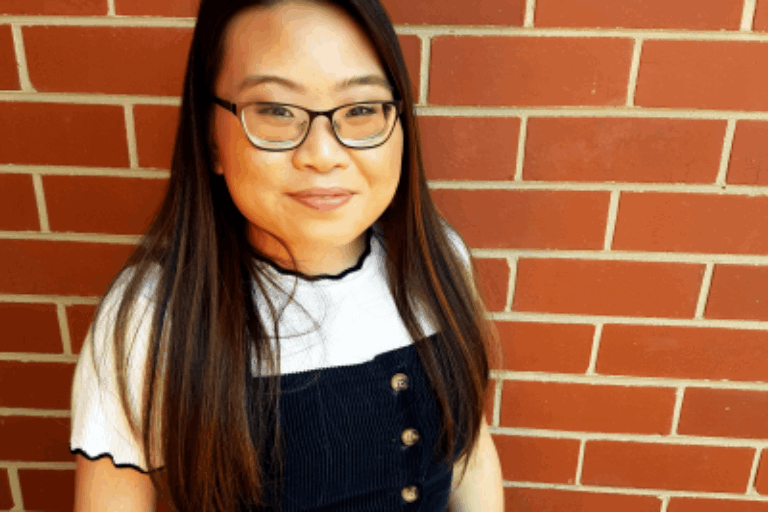 Cindy, a young Asian woman with long straight hair and glasses.