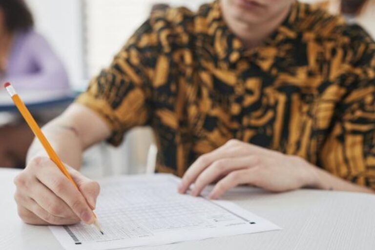 A close-up of a person with a colourful shirt doing an exam in a classroom